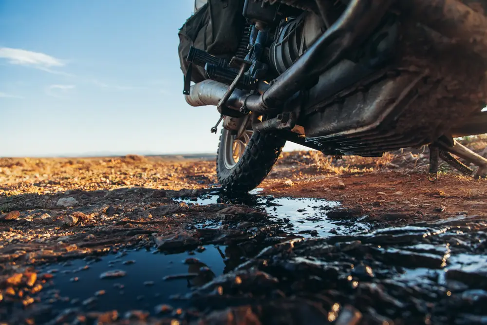 A rouge rock cracks the sump of my bike, emptying all 2 litres of oil onto the dirt. The risk of riding without a sump guard ends the motorcycling journey here